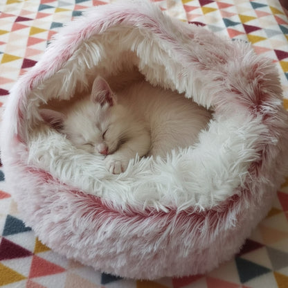 Niche pour chat ultra moelleux rose poser sur une couverture avec triangles de couleurs avec un chaton blanc