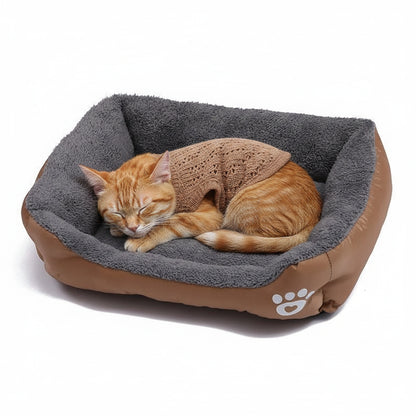 niche pour chat reversible marron avec un chat qui dort avec une tenue marron
